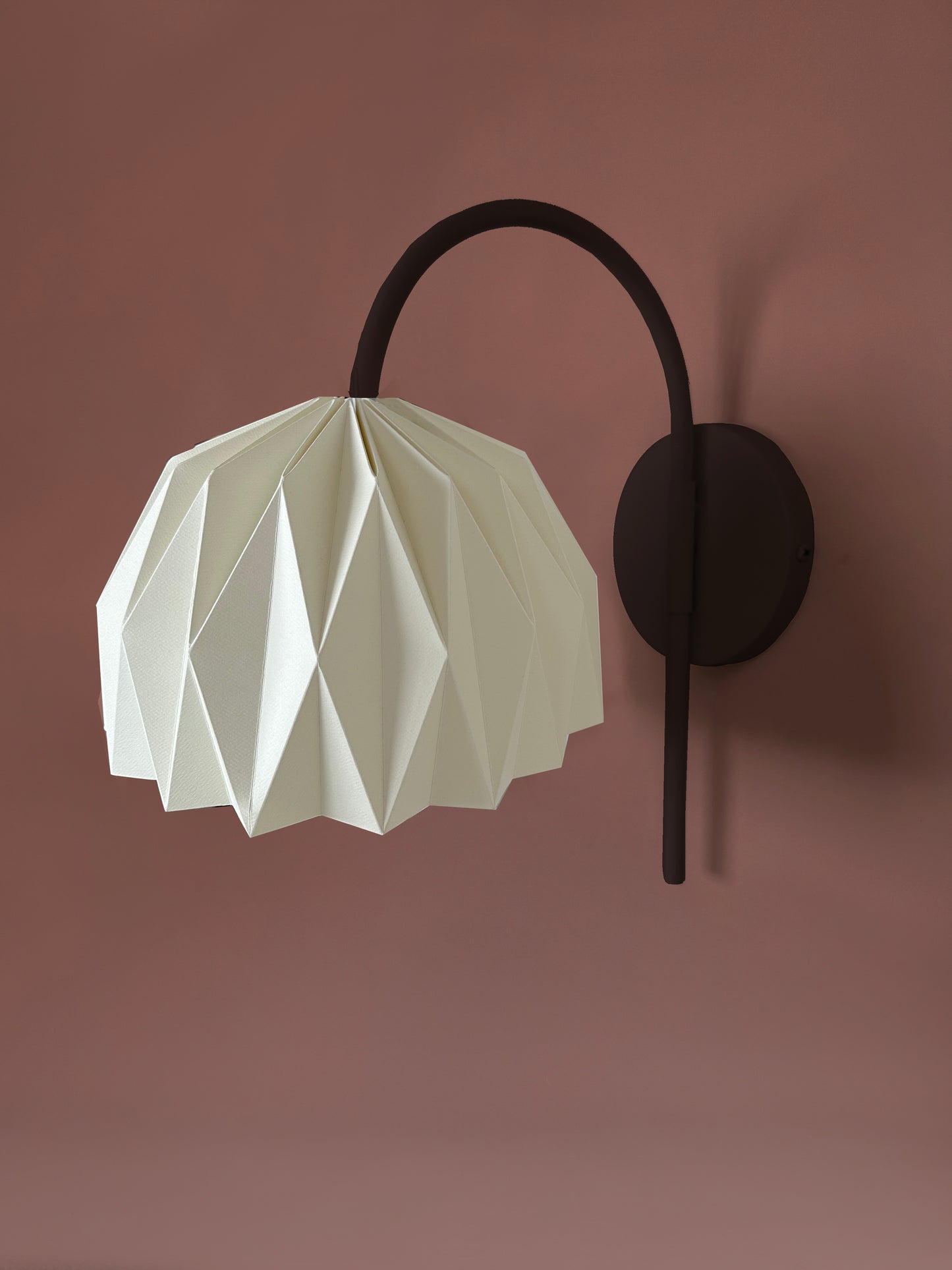 Plie Lights, lámparas hechas en Colombia a mano, por artesanos colombianos. La caperuza es de papel doblado a mano con un diseño geometrico. Soporte metálico color negro. Perfectas para iluminar habitaciones y mesas de noche.