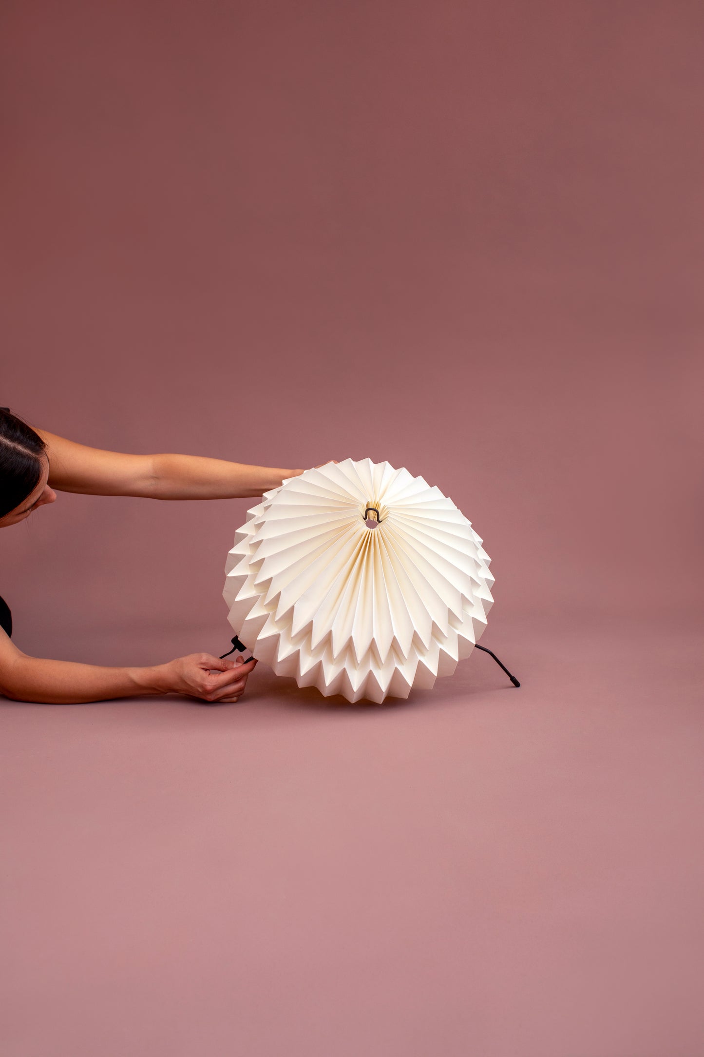 Lámparas Plié referencia Atria fabricada con base metálica y caperuza hecha en papel plegado. Perfecta para iluminar espacios y dar un brillo a los espacios. Lámpara de mesa o lámpara de piso.