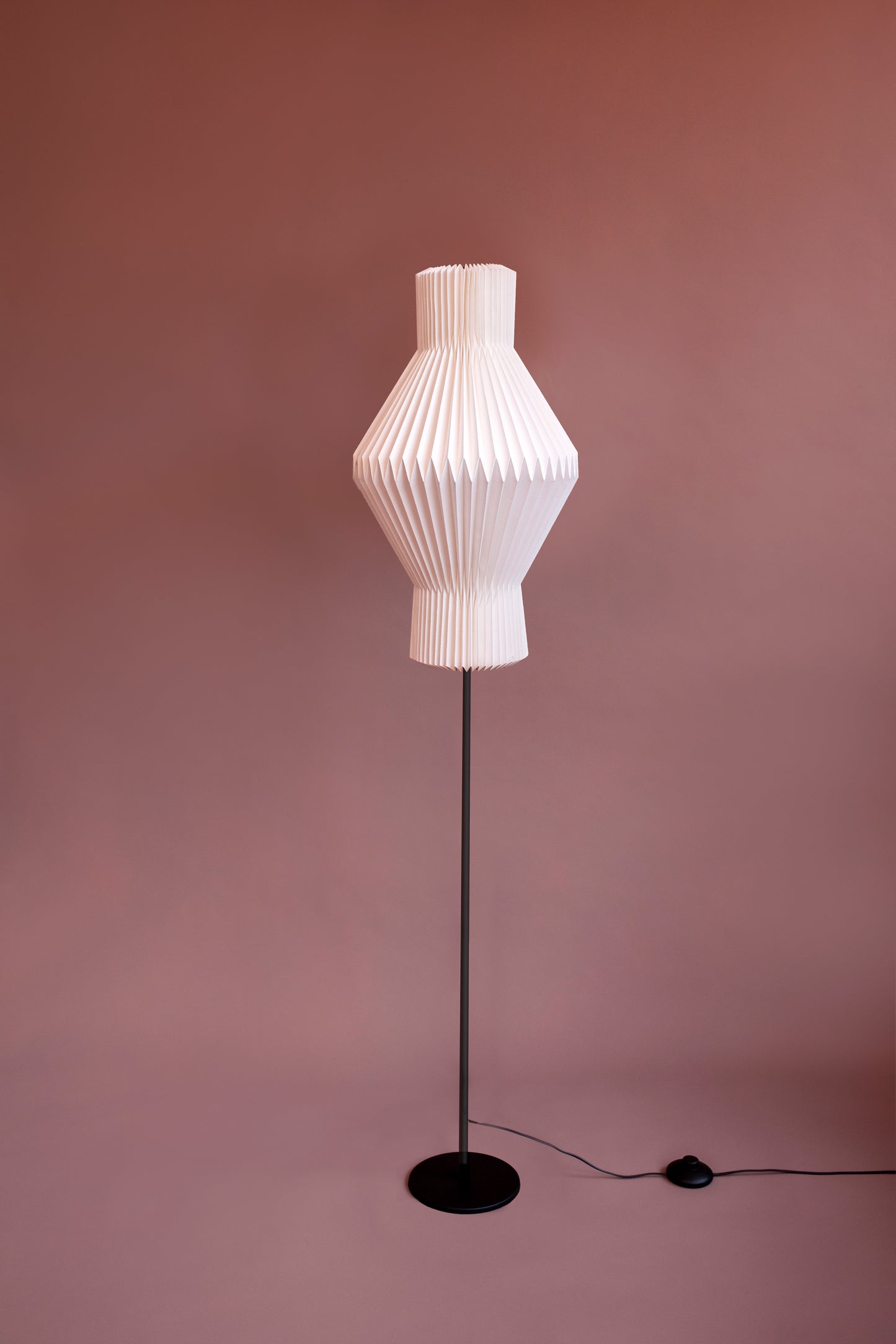 Plié Lights_lámpara de piso referencia Hydra. Lámpara de 155 cm de alto, con caperiza en papel una figura geometrica hecha en orginami con base metálica negra. Lámparas de Colombia, diseñadas y hechas a mano en Colombia.