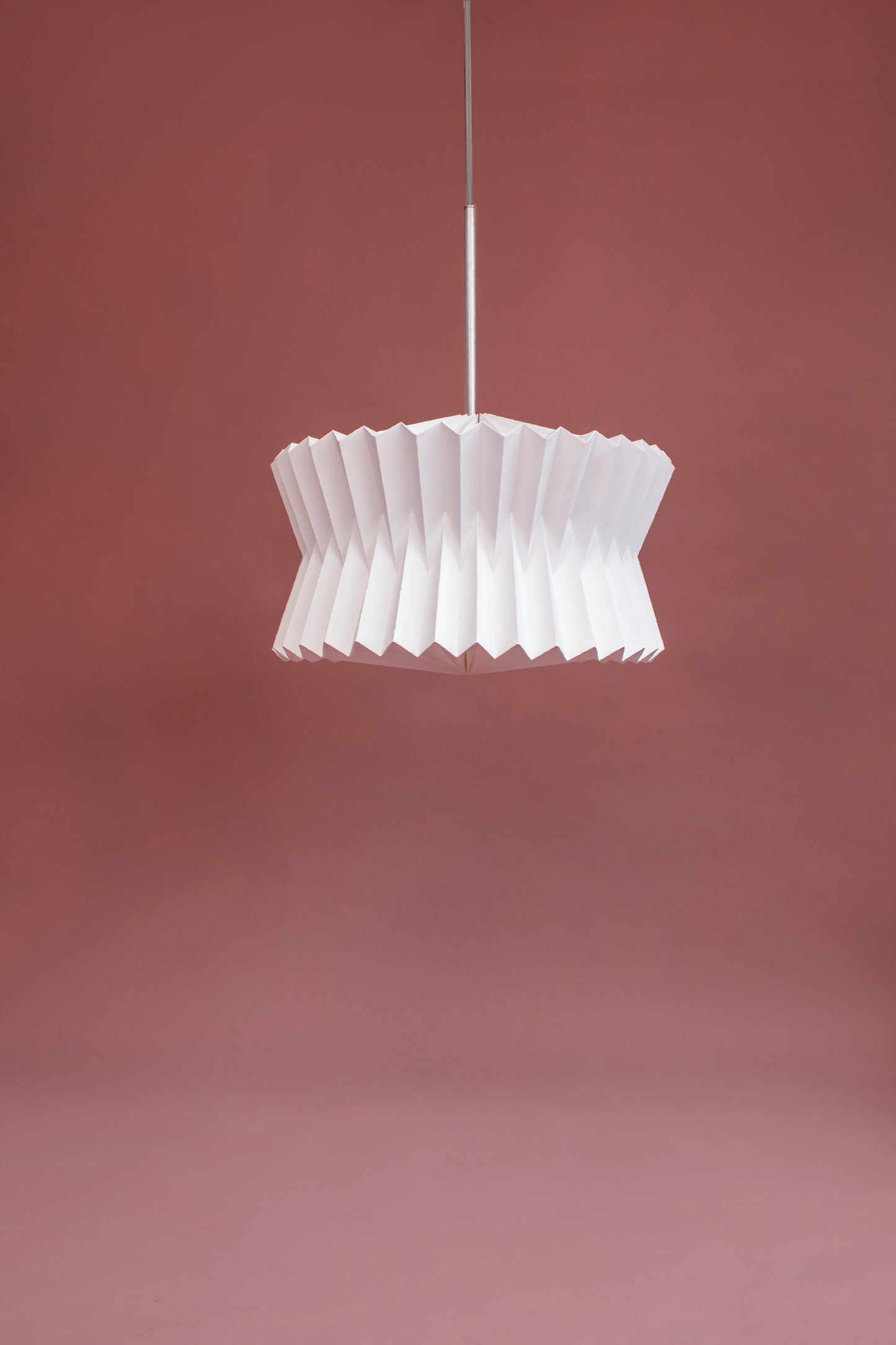 Lámpara colgante marca Plié referencia Altair con base metálica acabado blanco. Caperuza liviana hecha de papel plegado. Ideal para iluminar espacios y darle diseño al hogar. Diseño Colombiano, hecho a mano.