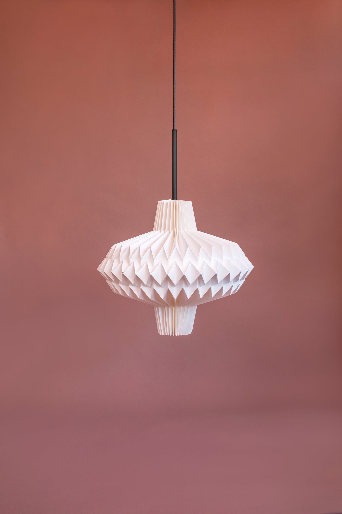 Lámpara Colgante marca Plié, referencia Antares fabricada con papel plegado y una figura geométrica muy interesante. Ideal para iluminar y darle calidez a los espacios. Tamaño mediano.