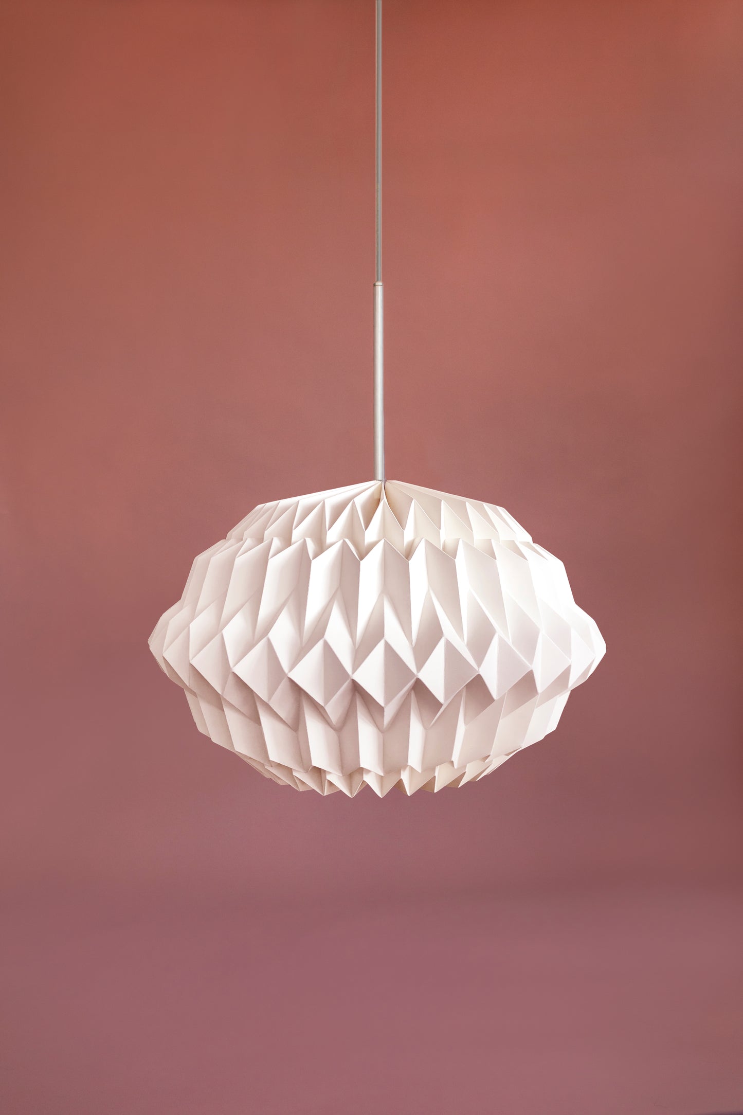 Plié Lights, lámpara colgante referencia libra, hecha a mano, caperuza hecha en papel plegado a mano. Soporte metálica y cable transparente. Acabado blanco. Producto hecho en Colombia. Diseño Colombiano. igura geométrica muy interesante. Ideal para iluminar y darle calidez a los espacios.