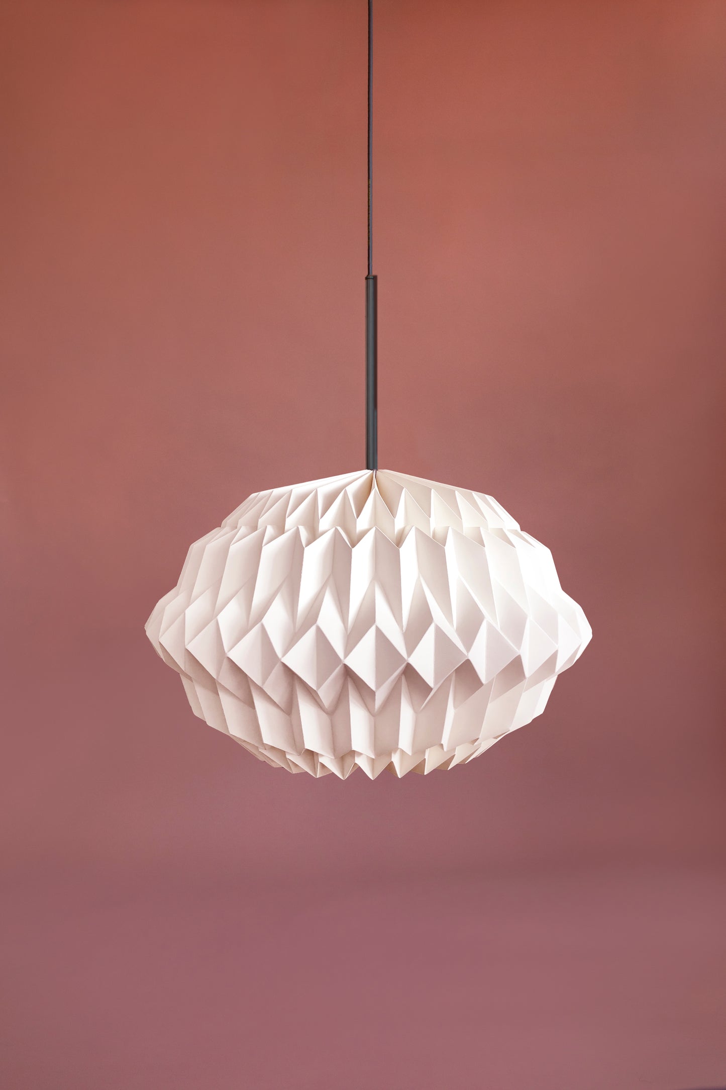 Plié Lights, lámpara colgante referencia libra, hecha a mano, caperuza hecha en papel plegado a mano. Soporte metálica y cable negro Acabado negro. Producto hecho en Colombia. Diseño Colombiano. Figura geométrica muy interesante. Ideal para iluminar y darle calidez a los espacios.