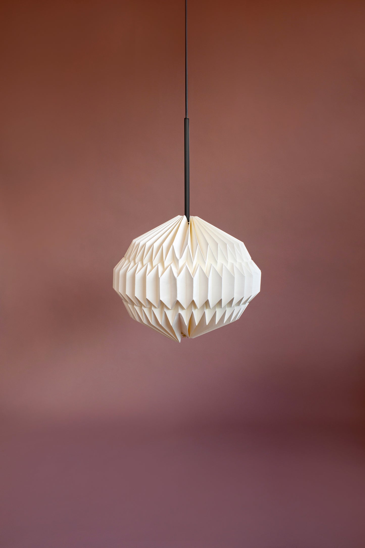 Lámpara colgante marca Plié, referencia Orión caperuza fabricada con papel plegado y base metálica con un diseño colombiano y figura geométrica muy interesante. Ideal para iluminar y darle calidez a los espacios.