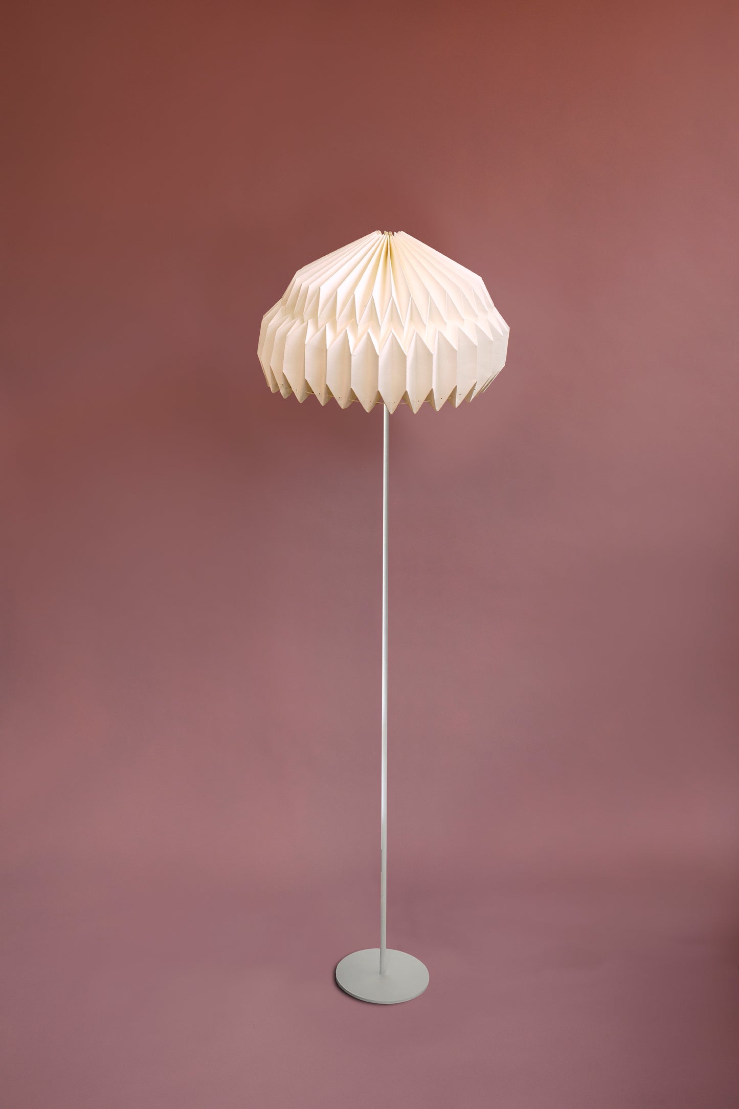Lámpara de piso marca Plié referencia Alfa. Fabricada con base metálica y caperiza hecha en papel. Diseño colombiano hecho a mano. Acabado blanco. Ideal para iluminar espacios cálidos. Figura geométrica.