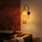 Plié Lights_Lampara de pared_aplique de pared_Fotografía de producto_Diseño geometrico_Hechas en papale doblada_con manos colombianas._Fotografía nocturna en sitio en una sala con una sofá y un cuadro. 