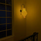 Plié Lights_Lampara de pared_aplique de pared_Fotografía de producto_Diseño geometrico_Hechas en papale doblada_con manos colombianas._Fotografía nocturna en sitio en unas escaleras, se veuna ventana al lado._Caperuza referencia Hydra