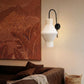 Plié Lights_Lampara de pared_aplique de pared_Fotografía de producto_Diseño geometrico_Hechas en papale doblada_con manos colombianas._Fotografía de dia en sitio en una sala con una sofá y un cuadro. 