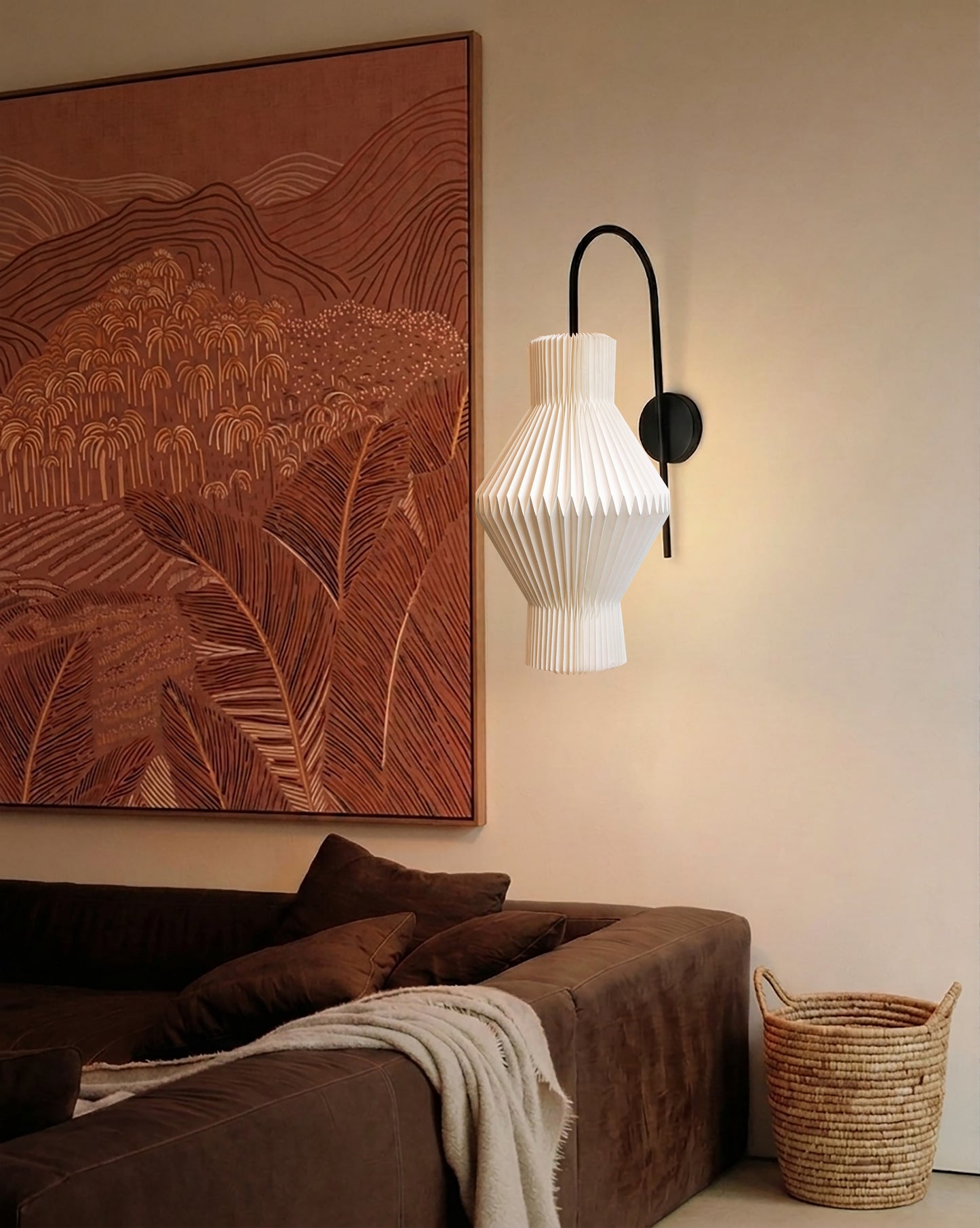 Plié Lights_Lampara de pared_aplique de pared_Fotografía de producto_Diseño geometrico_Hechas en papale doblada_con manos colombianas._Fotografía de dia en sitio en una sala con una sofá y un cuadro. 