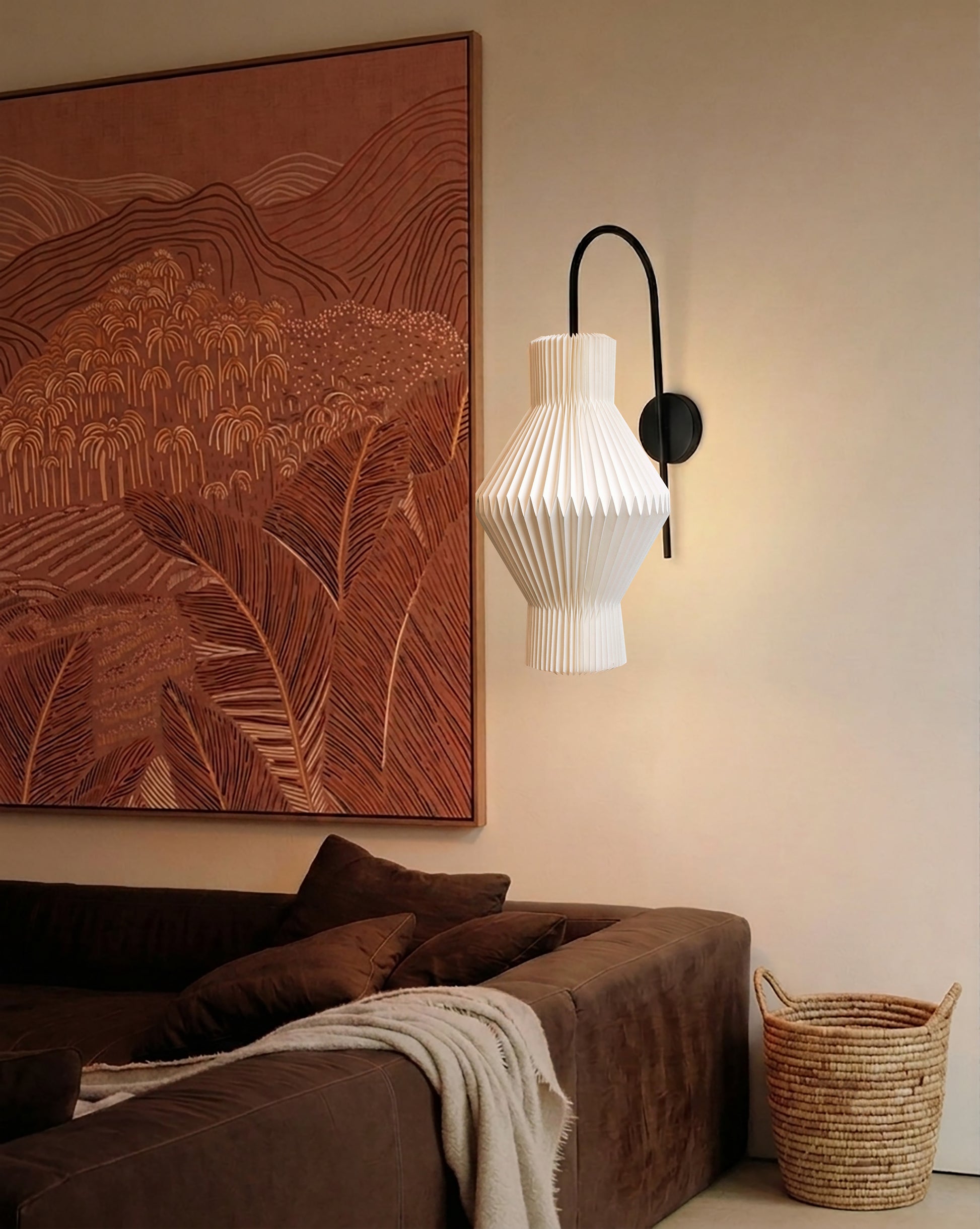 Plié Lights_Lampara de pared_aplique de pared_Fotografía de producto_Diseño geometrico_Hechas en papale doblada_con manos colombianas._Fotografía de dia en sitio en una sala con una sofá y un cuadro. 