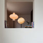Lámpara de piso con caperuza redonda fabricada en papel al lado de otra lámpara de piso
